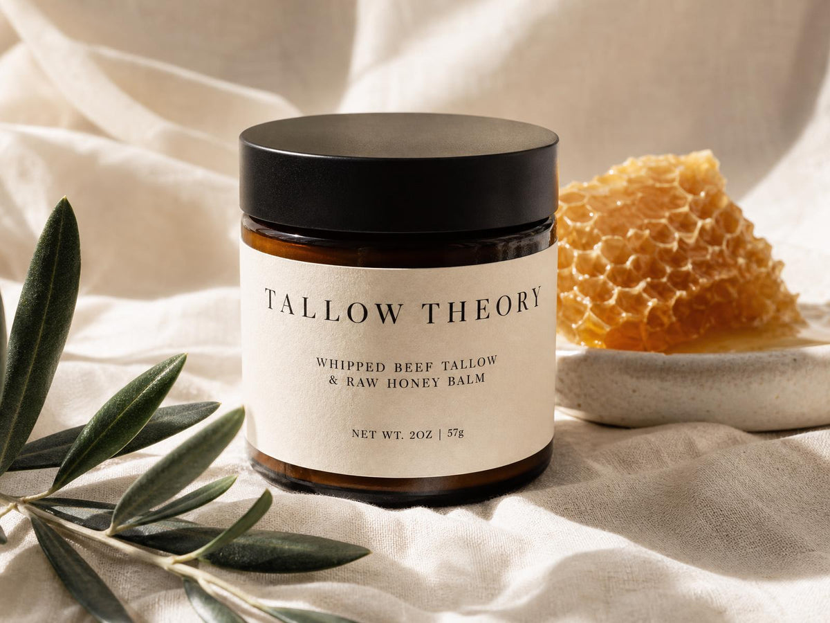 Tallow Theory Whipped Beef Tallow & Raw Honey Balm amber jar with cream label on linen with honeycomb and olive branch